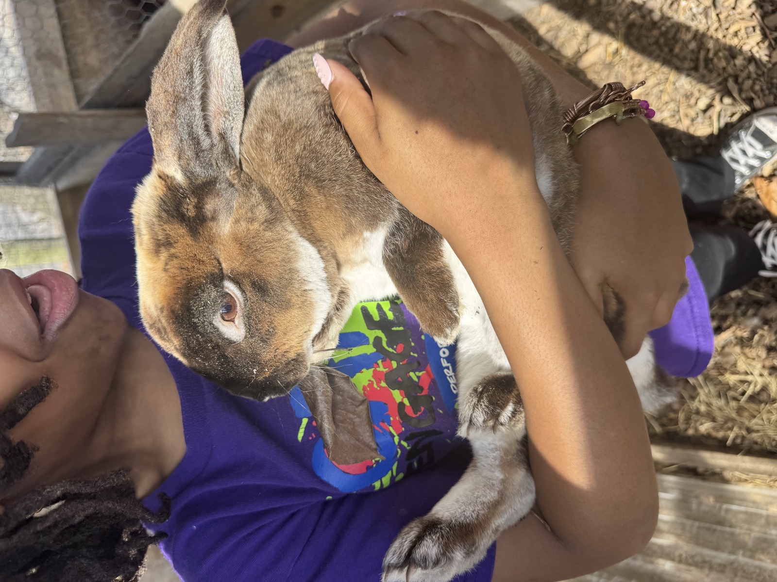 An emerging leader practicing compassionate animal care at the Oasis Youth Farm